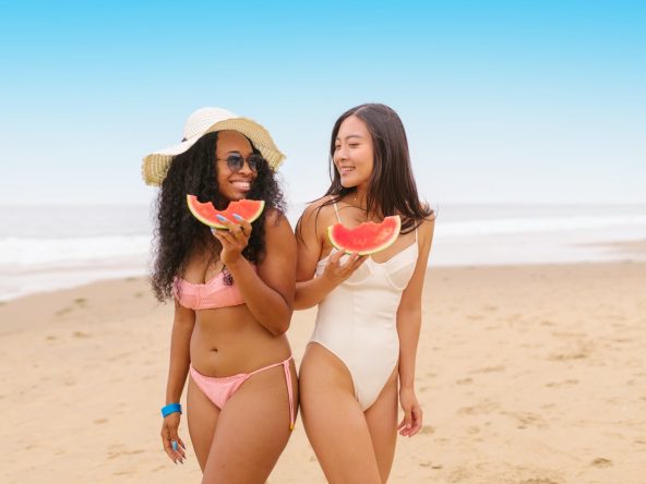 Two women smiling at a beach